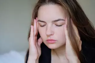 fotopsias_mujer_con_fotopsias_estres_dra_ximena_mira_queretaro_320x213 Mujer joven con ojos cerrados tocandose las sienes por estres visual relacionado con fotopsias en Queretaro